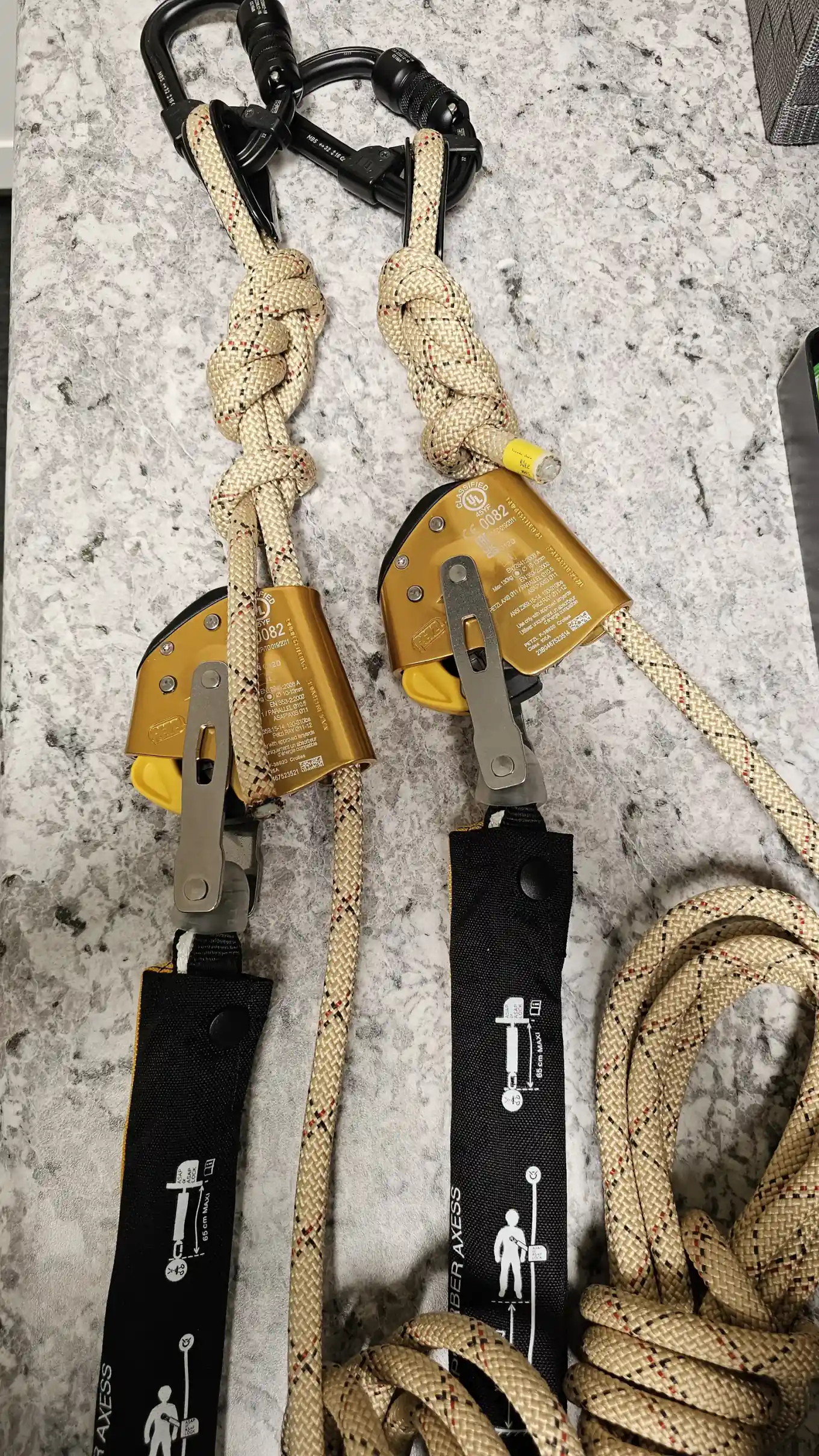 Two Petzl ASAP fall arresters on knotted tan rope, each joined to an ASAP'SORBER AXESS energy absorber, with locking carabiners above and a coiled rope alongside