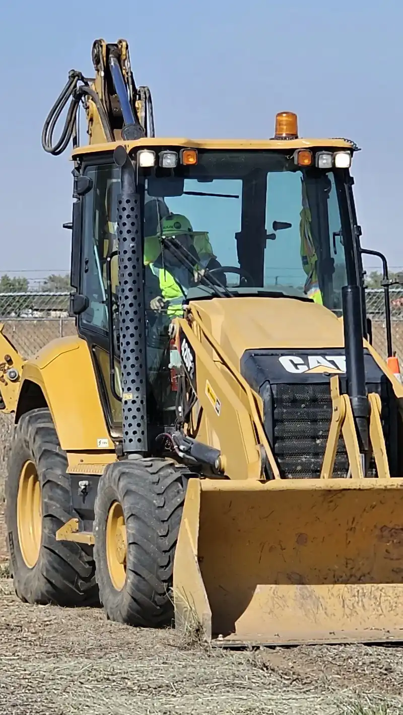 A backhoe operator in the cab during heavy equipment training