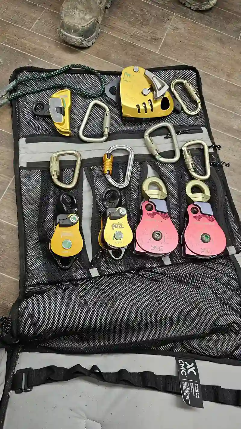 An open CMC rescue bag holding pulleys, carabiners and rope rescue hardware