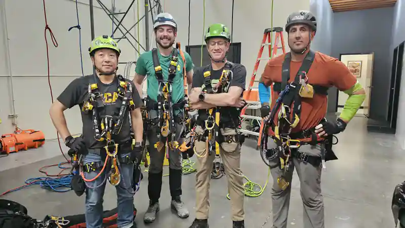 Four rope access graduates in harnesses and helmets after SPRAT training at the Phoenix Safety Training Center